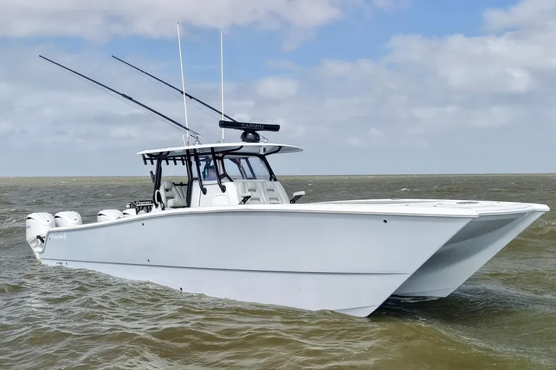 Slide: The Image of 2024 Freeman 38 boat on water, equipped with fishing rods and Garmin technology. - 2