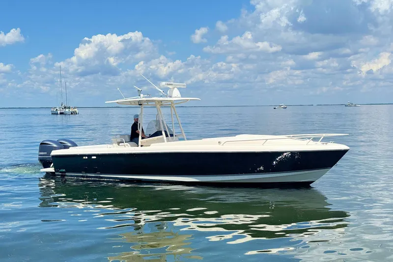 The Image of 2003 Intrepid 322 Cuddy boat cruising on calm waters under a blue sky. - 1
