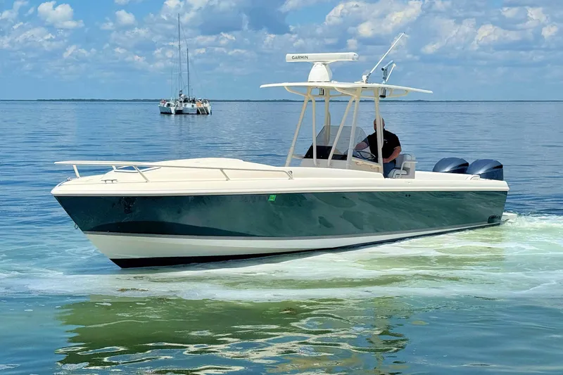 Slide: The Image of 2003 Intrepid 322 Cuddy boat cruising on calm water under a blue sky. - 10