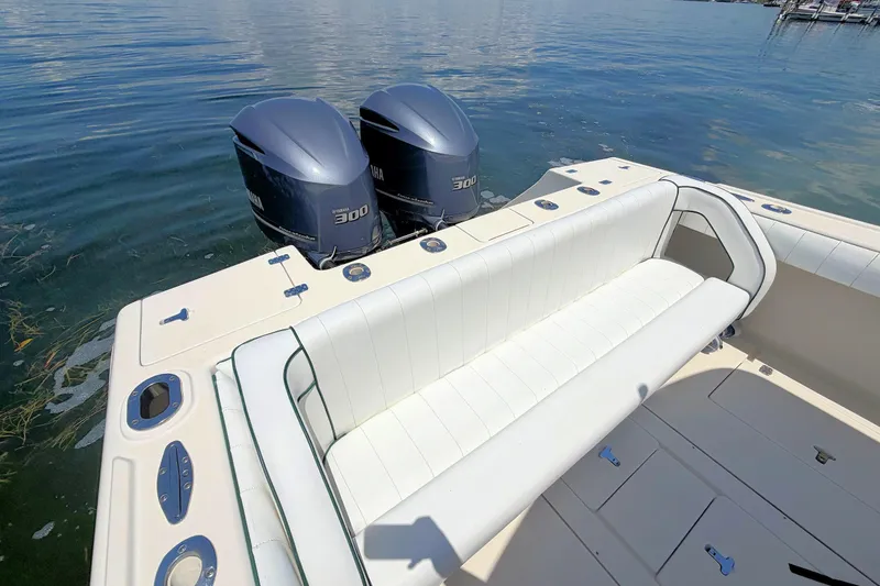 Slide: The Image of 2003 Intrepid 322 Cuddy boat with twin Yamaha 300 engines and white seating. - 15