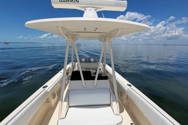 Slide: The Image of 2003 Intrepid 322 Cuddy boat on calm water under clear blue sky. - 19