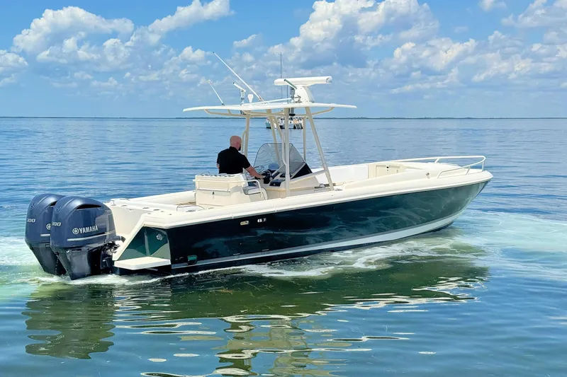 Slide: The Image of 2003 Intrepid 322 Cuddy boat cruising on calm waters under a clear sky. - 3