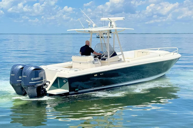 Slide: The Image of 2003 Intrepid 322 Cuddy boat cruising on calm water with twin Yamaha engines. - 4