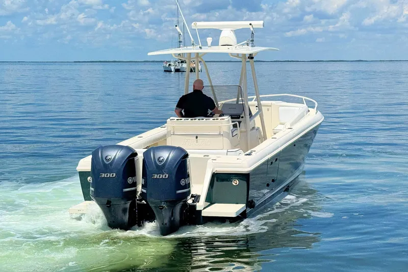 Slide: The Image of 2003 Intrepid 322 Cuddy boat with dual Yamaha 300 engines on calm water. - 5