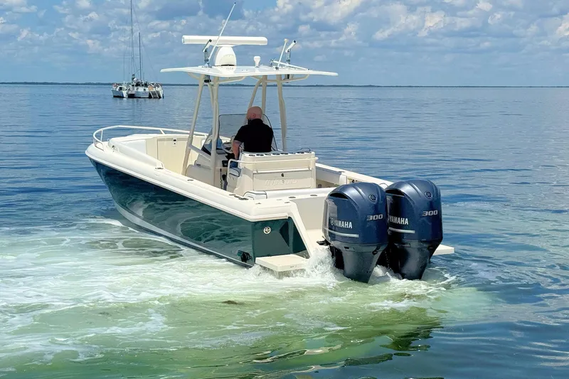 Slide: The Image of 2003 Intrepid 322 Cuddy boat with dual Yamaha 300 engines on calm water. - 7