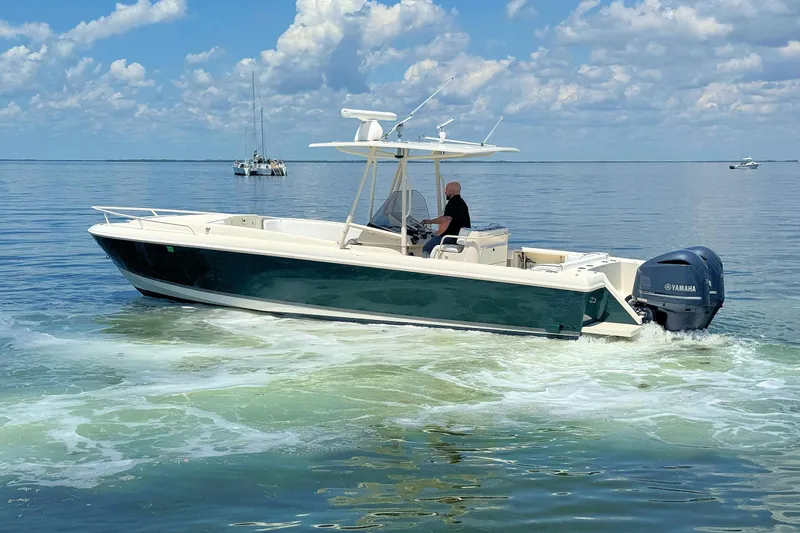 Slide: The Image of 2003 Intrepid 322 Cuddy boat cruising on calm waters under a blue sky. - 8