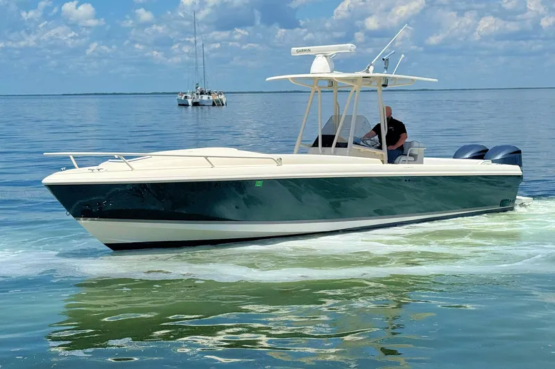 Slide: The Image of 2003 Intrepid 322 Cuddy boat cruising on calm waters under a blue sky. - 9