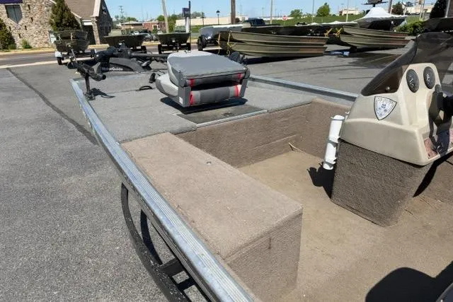Slide: The Image of 1999 Tracker Pro Team 165 boat interior with seating and console, parked outdoors. - 4