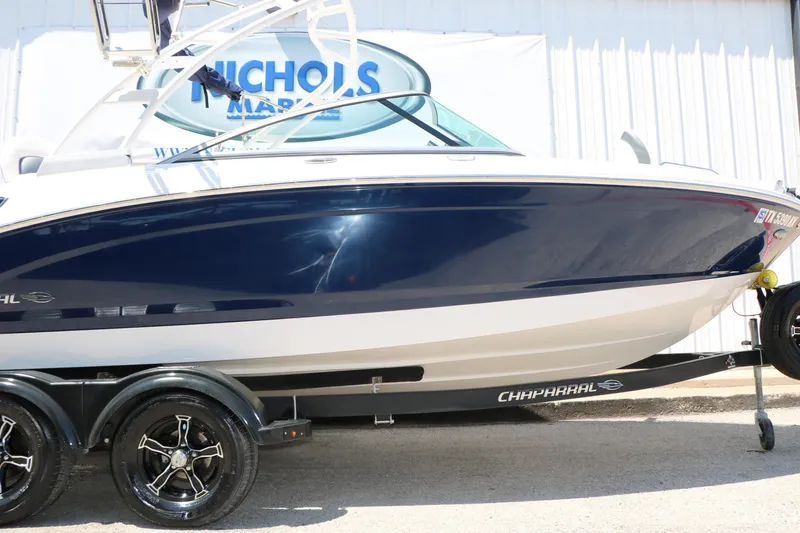 Slide: The Image of 2021 Chaparral 21 SSi Ski & Fish boat on trailer, blue and white exterior. - 16