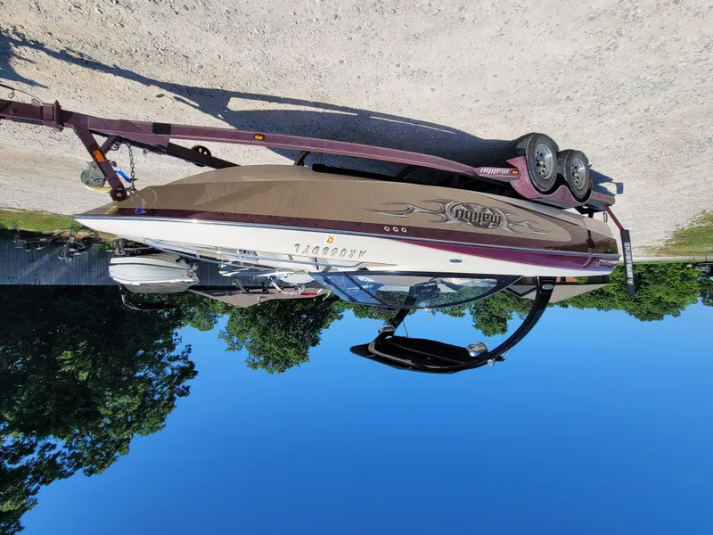 Slide: The Image of 2005 Malibu XTI boat on trailer under blue sky. - 14