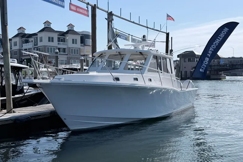 The Image of 2025 NorthCoast 415 HT boat docked at marina with waterfront buildings. - 0