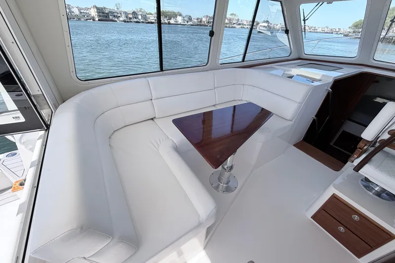 Slide: The Image of Luxurious interior of 2025 NorthCoast 415 HT yacht with white seating and wooden table. - 14