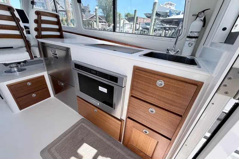 Slide: The Image of Interior of 2025 NorthCoast 415 HT boat featuring modern kitchenette with wood accents. - 17