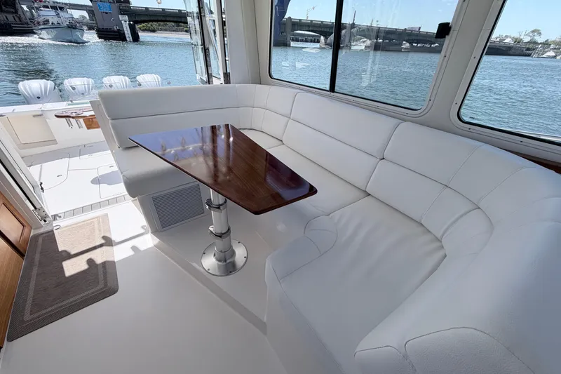 Slide: The Image of Luxurious interior of 2025 NorthCoast 415 HT yacht with white seating and wooden table. - 19
