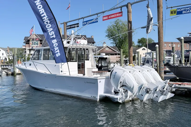 Slide: The Image of 2025 NorthCoast 415 HT boat docked, featuring triple outboard engines and a sleek design. - 2
