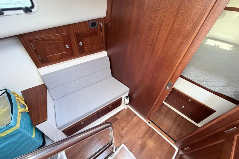 Slide: The Image of Interior of 2025 NorthCoast 415 HT boat, featuring wood paneling and a cozy seating area. - 22