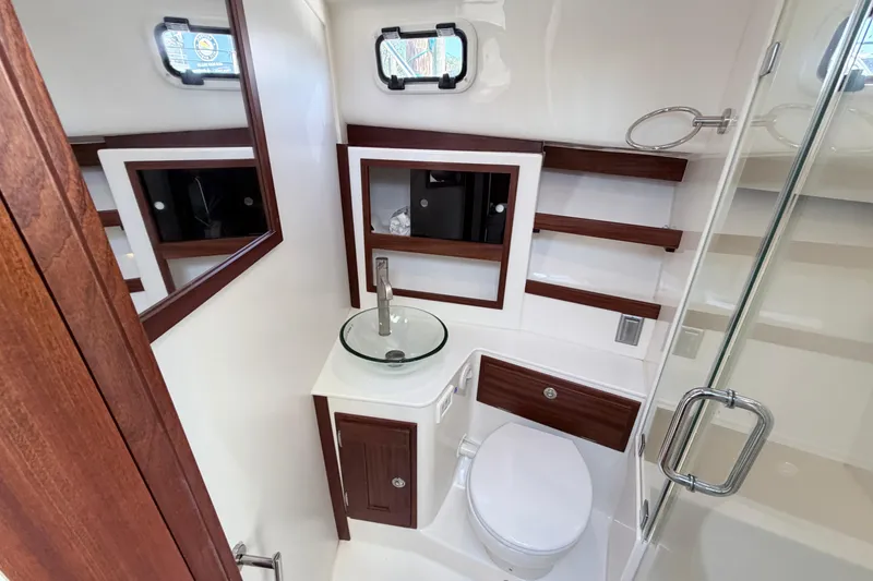 Slide: The Image of Luxurious bathroom in 2025 NorthCoast 415 HT boat, featuring modern fixtures and elegant wood accents. - 25