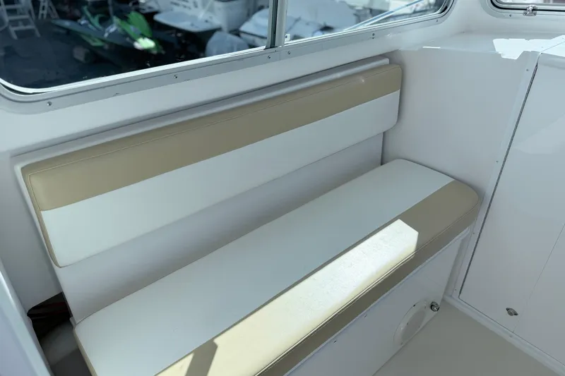 Slide: The Image of Interior seating of 2018 Steiger Craft 25 Chesapeake boat, featuring beige and white cushions. - 11