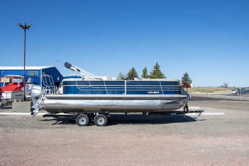 The Image of 2017 Starcraft EX23 R pontoon boat on trailer outdoors. - 1