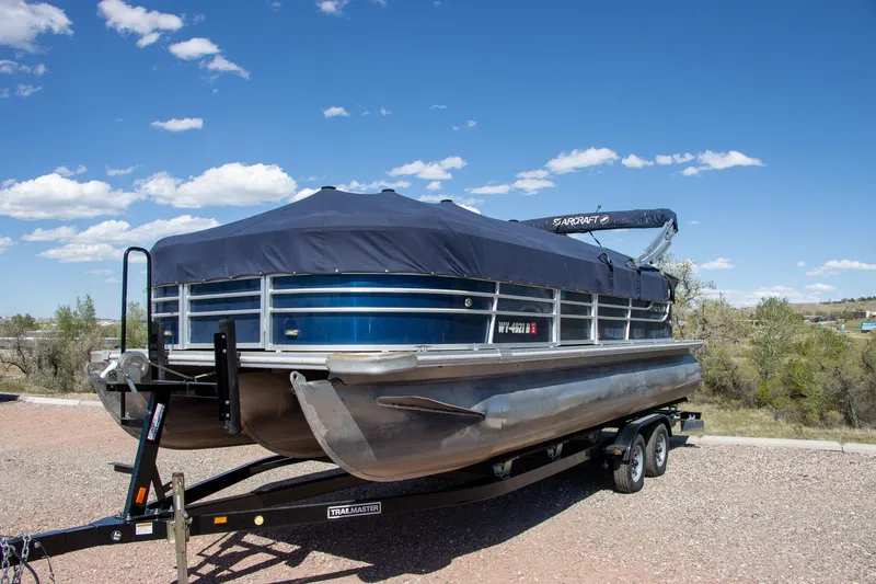 Slide: The Image of 2017 Starcraft EX23 R pontoon boat on trailer under blue sky. - 3