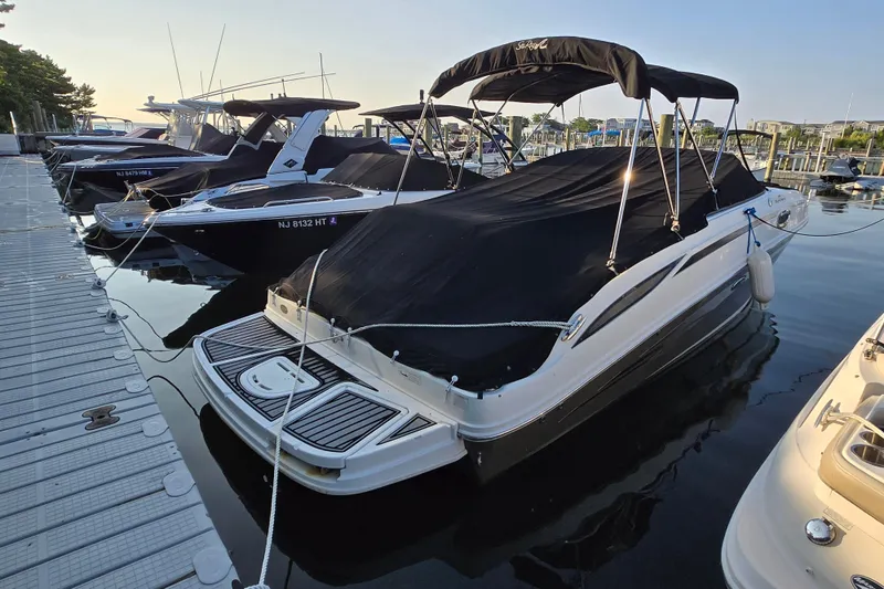 The Image of 2012 Sea Ray 260 Sundeck boat docked with cover, marina setting. - 0