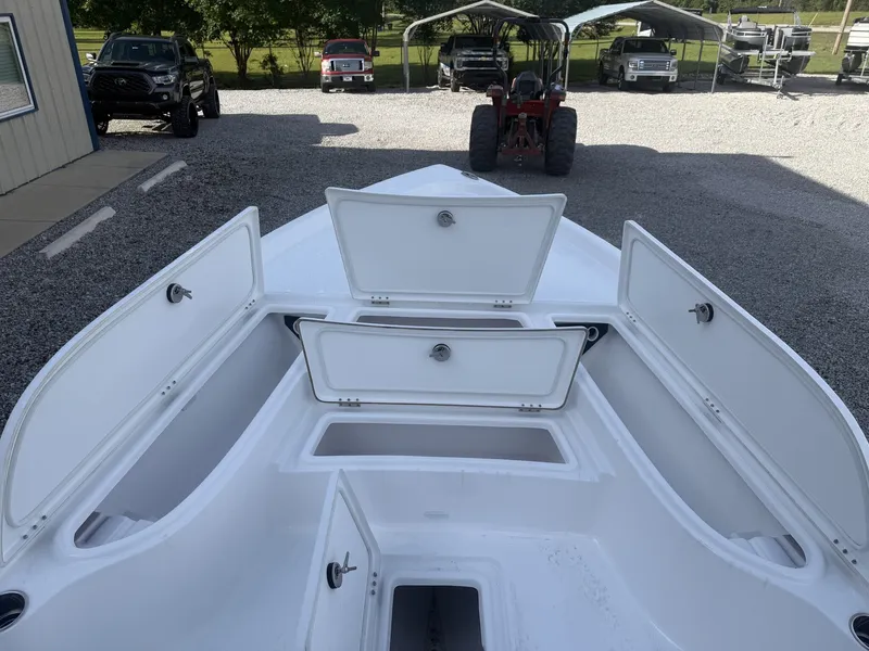 Slide: The Image of Blazer Purebay 2026 boat with open storage compartments on gravel lot. - 4
