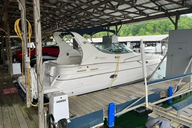 The Image of 1999 Cruisers Yachts 3075 Express docked in a covered marina slip. - 0