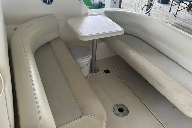Slide: The Image of 1999 Cruisers Yachts 3075 Express interior with white seating and table. - 12