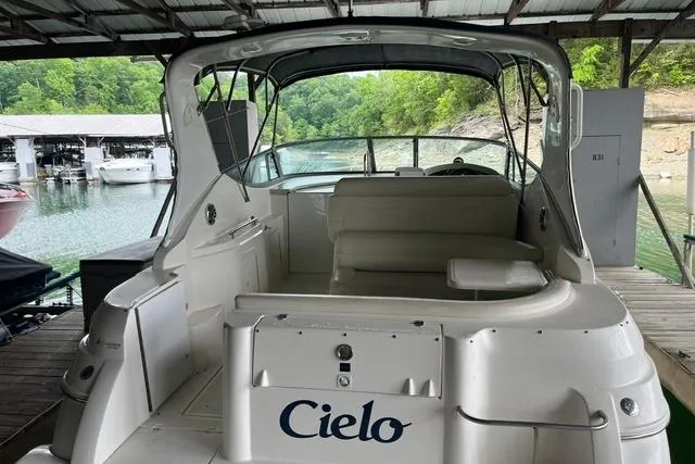 Slide: The Image of 1999 Cruisers Yachts 3075 Express docked, rear view with seating area, under covered marina. - 2