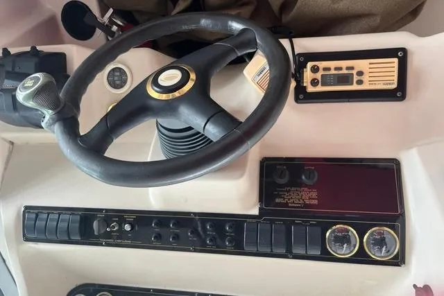 Slide: The Image of 1999 Cruisers Yachts 3075 Express dashboard with steering wheel and control panel. - 5