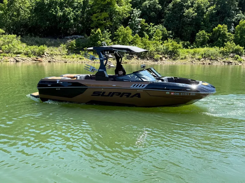 Slide: The Image of 2021 Supra SE 550 boat on a green lake. - 27