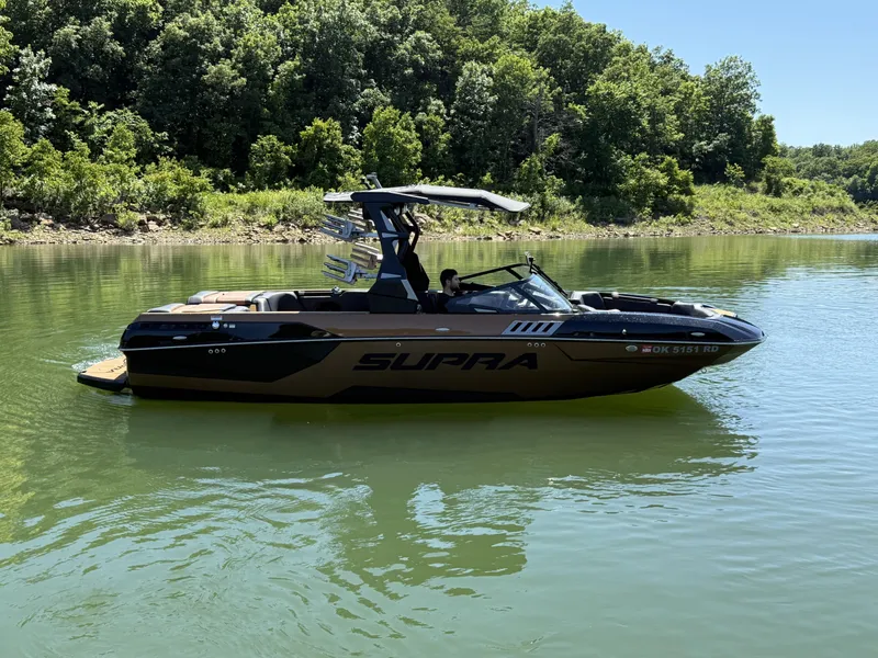 Slide: The Image of 2021 Supra SE 550 boat on calm lake with forest backdrop. - 9