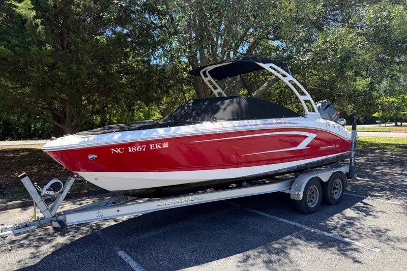 The Image of 2019 Chaparral 21 H2O Sport OB boat on trailer, parked under trees. - 1