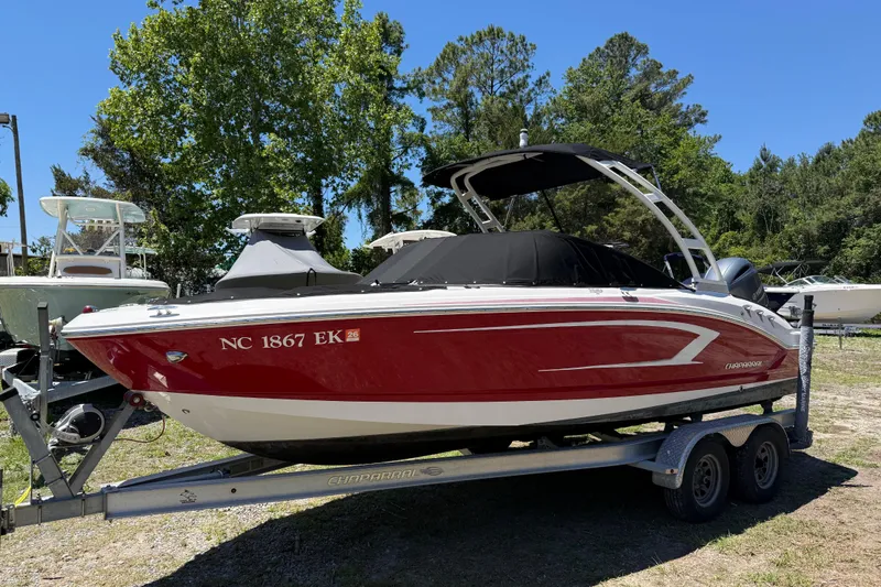 Slide: The Image of 2019 Chaparral 21 H2O Sport OB boat on trailer, red and white design, parked outdoors. - 10