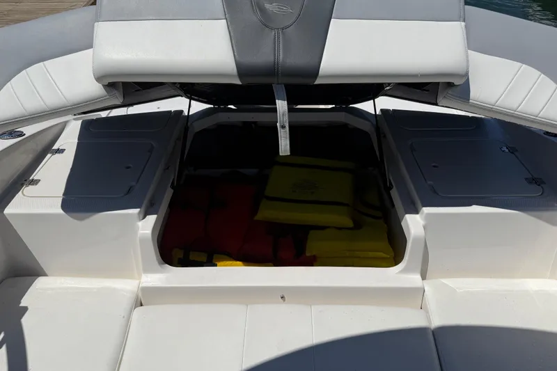 Slide: The Image of 2019 Chaparral 21 H2O Sport OB boat storage compartment with life jackets inside. - 18