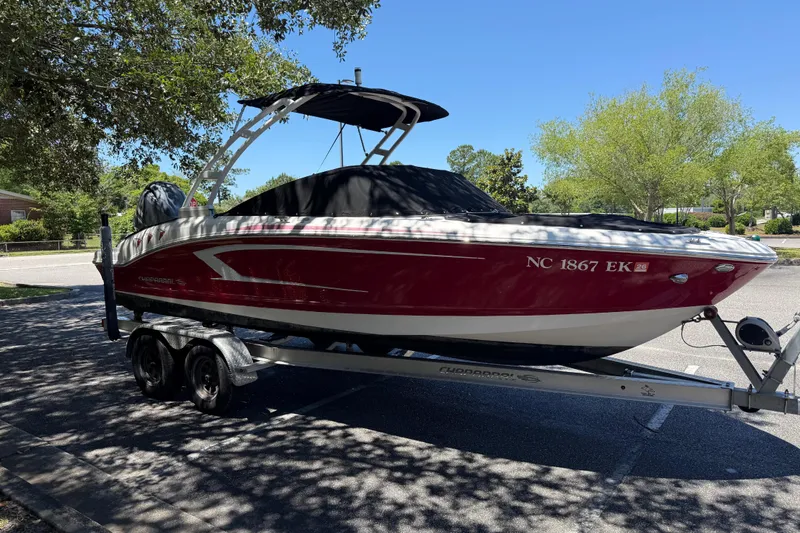 Slide: The Image of 2019 Chaparral 21 H2O Sport OB boat on trailer, parked under trees. - 6