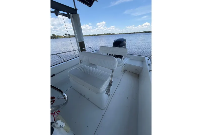 Slide: The Image of 2012 Boston Whaler 190 Montauk boat interior with seating, on a calm lake. - 10