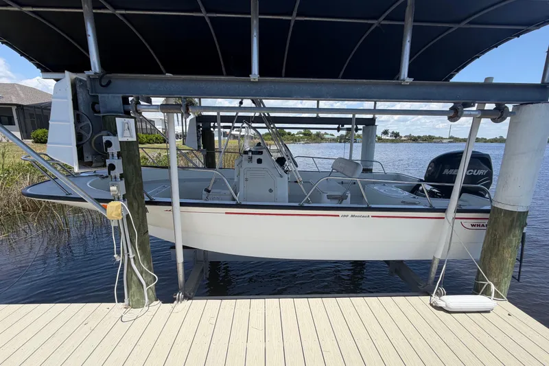 Slide: The Image of 2012 Boston Whaler 190 Montauk boat on lift by waterfront dock. - 3
