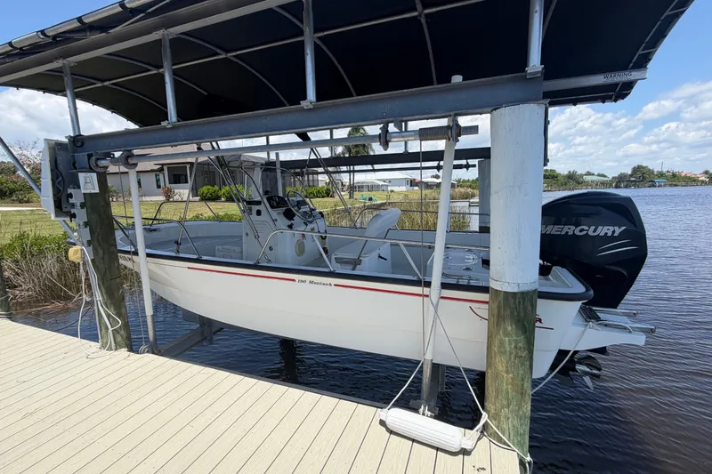 Slide: The Image of 2012 Boston Whaler 190 Montauk boat on lift by waterfront dock. - 4