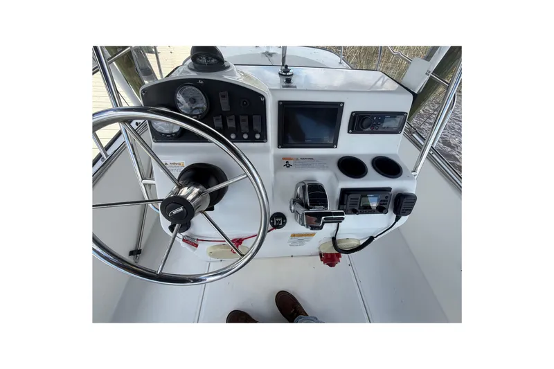 Slide: The Image of 2012 Boston Whaler 190 Montauk boat console with steering wheel and navigation controls. - 5