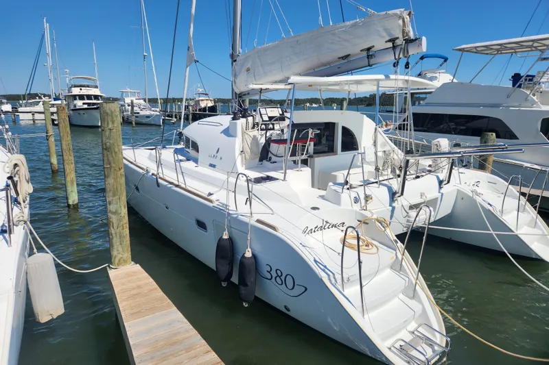 The Image of 2019 Lagoon 380 catamaran docked at marina, surrounded by other boats. - 0