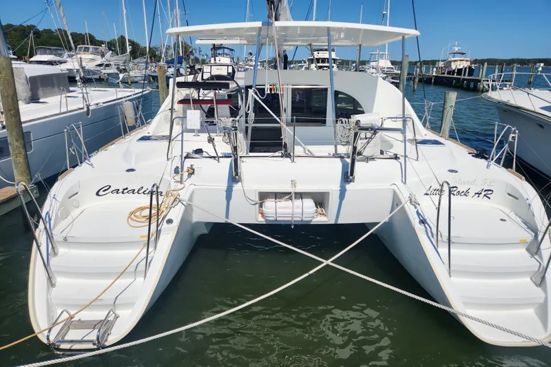 Slide: The Image of 2019 Lagoon 380 catamaran docked at marina, featuring spacious deck and modern design. - 1