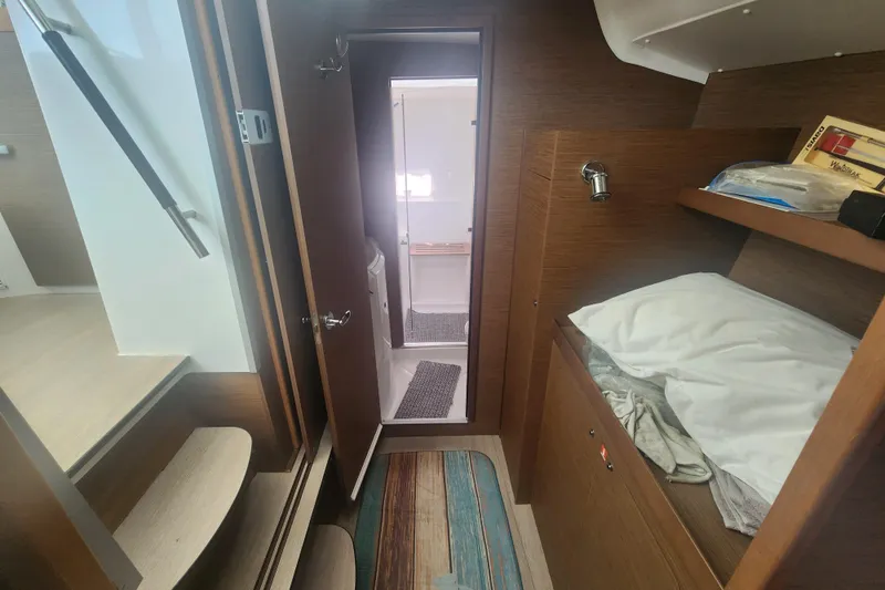 Slide: The Image of Interior of 2019 Lagoon 380 catamaran cabin with bed, stairs, and bathroom view. - 13