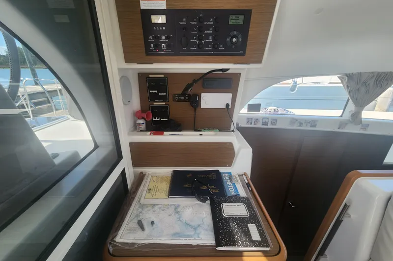 Slide: The Image of Navigation station inside a 2019 Lagoon 380 catamaran with charts and control panel. - 27