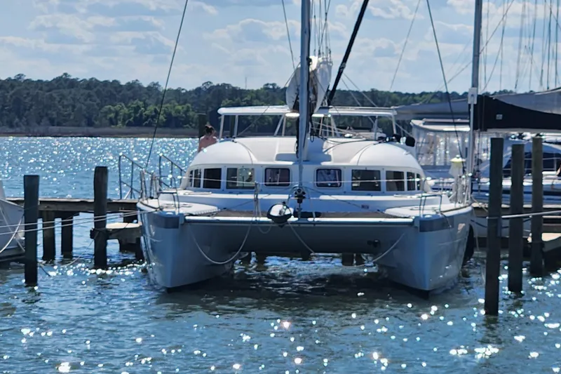 Slide: The Image of 2019 Lagoon 380 catamaran docked at a sunny marina. - 3