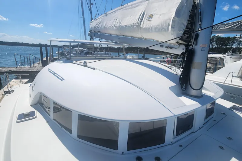 Slide: The Image of 2019 Lagoon 380 catamaran docked, showcasing sleek design and spacious deck under clear skies. - 32