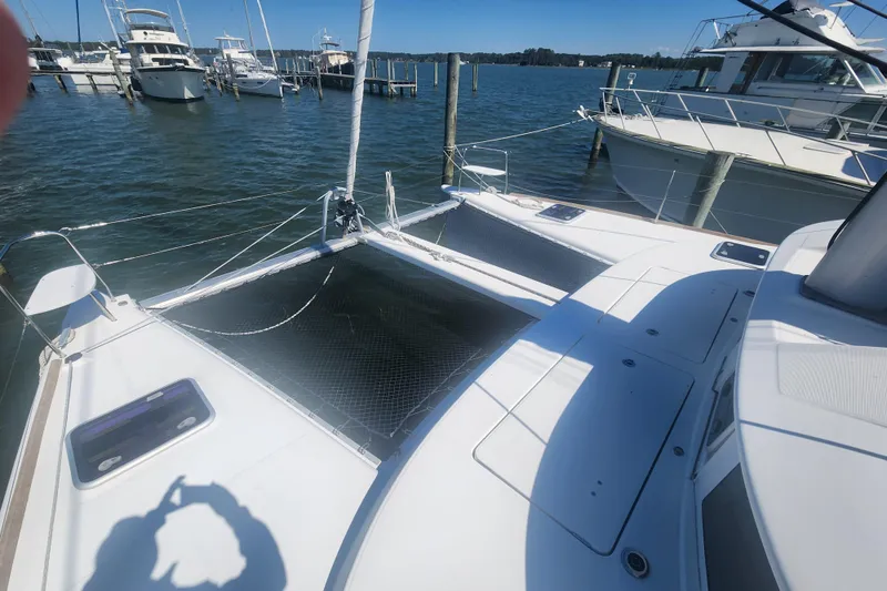 Slide: The Image of 2019 Lagoon 380 catamaran docked at marina, featuring spacious deck and netting. - 36
