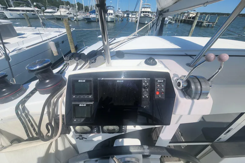 Slide: The Image of Cockpit of 2019 Lagoon 380 catamaran with navigation equipment and marina view. - 37