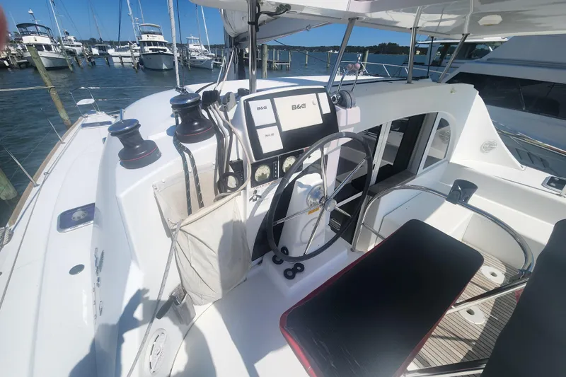 Slide: The Image of Cockpit of a 2019 Lagoon 380 catamaran docked at a marina, featuring navigation equipment. - 39