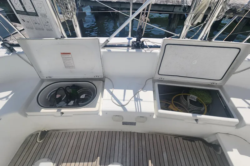 Slide: The Image of Storage compartments on a 2019 Lagoon 380 catamaran deck, featuring ropes and equipment. - 4